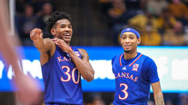 Feb 19, 2022; Morgantown, West Virginia, USA; Kansas Jayhawks guard Ochai Agbaji (30) talks with guard Dajuan Harris Jr. (3) during the first half against the West Virginia Mountaineers at WVU Coliseum. Mandatory Credit: Ben Queen-USA TODAY Sports